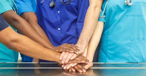 team of young doctors stacking hands