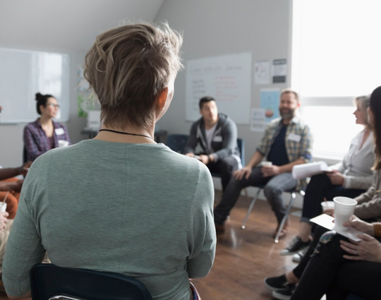 Group of people sitting in a circle having a discussion 