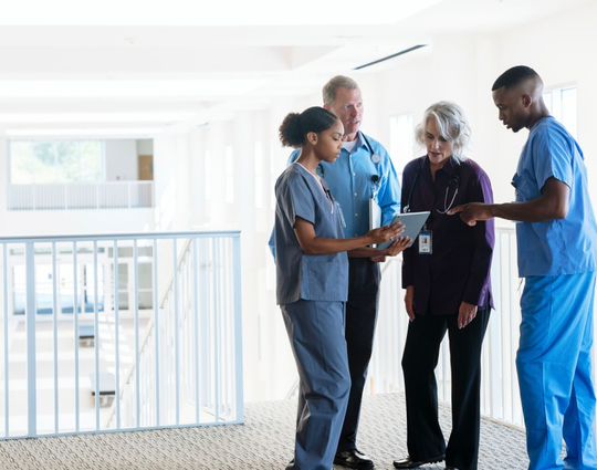 Doctors and nurses discussing digital tablet