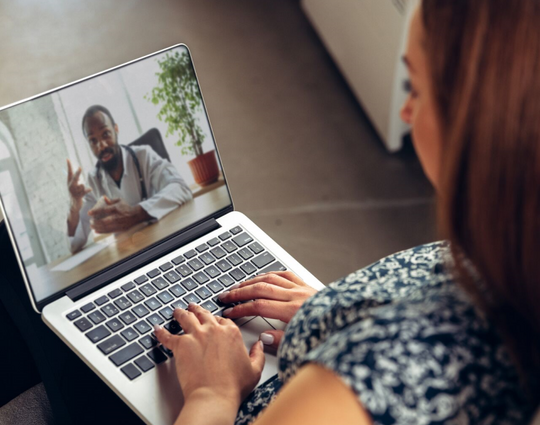 Young woman getting online medical help and advice during videocall with doctor